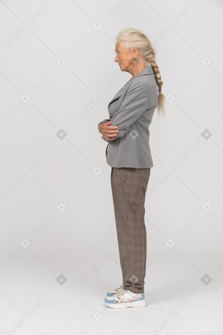 Side view of an old woman in suit posing with crossed arms