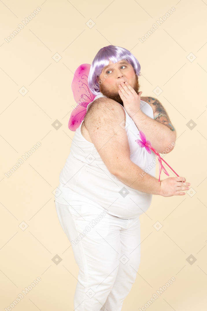 Gasping young overweight man holding fairy wand