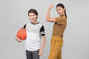 Pe teacher showing her bicep and her pupil standing next to her