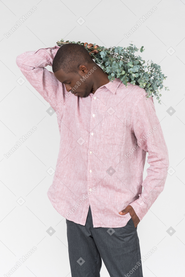 Good looking young man holding green branches