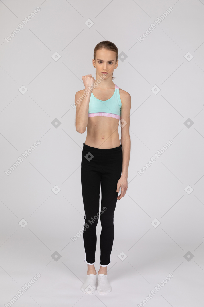 Angry teen girl in sportswear clenching her fist