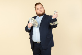 A plus-size man in a black costume with dollar bills in his hands