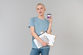 Süßer junger androgyner typ in einem hellblauen t-shirt und blue jeans, auf dem weg zum college