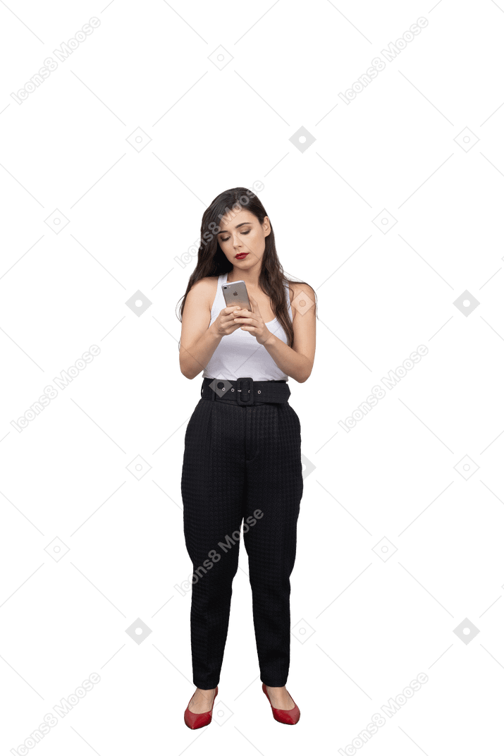 Vue de face d'une jeune femme en vêtements de bureau en regardant son téléphone