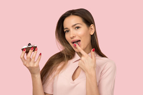 A woman holding a piece of cake in her hands