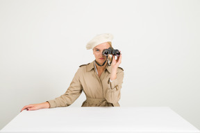 Fashionable woman looking through binocular