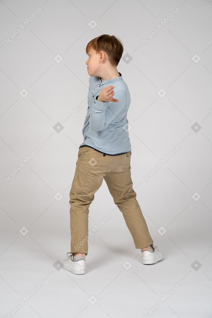 A boy standing in front of a wall