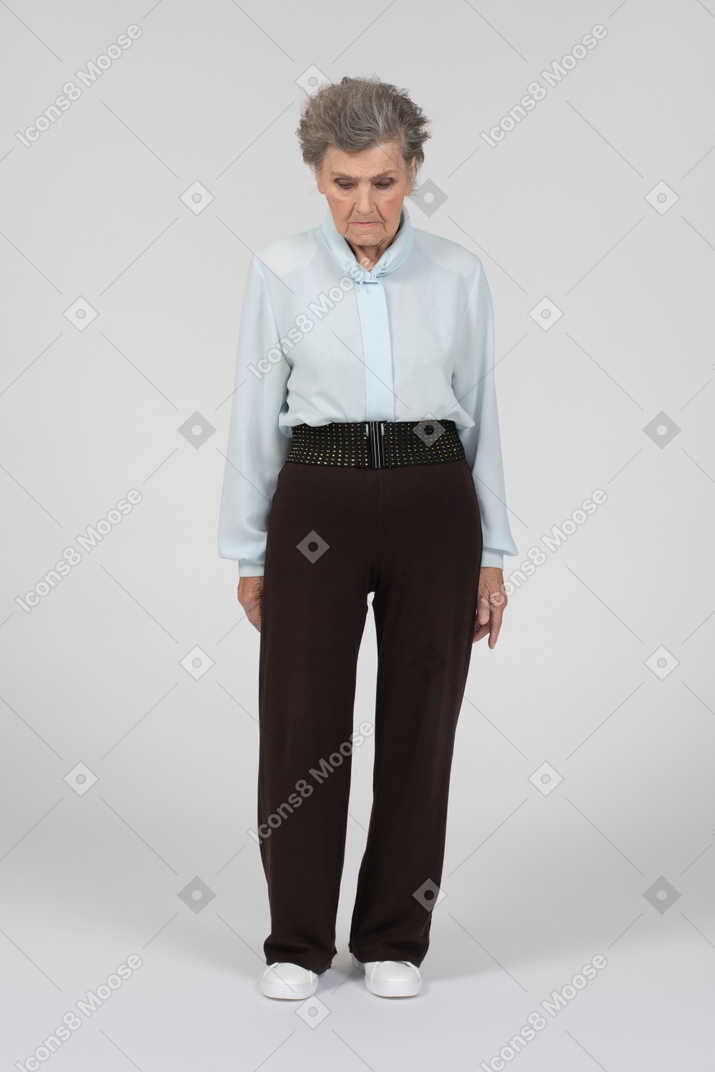 Old woman standing still with head down