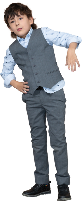 腰に手を置いて立っているスーツを着た少年の正面図