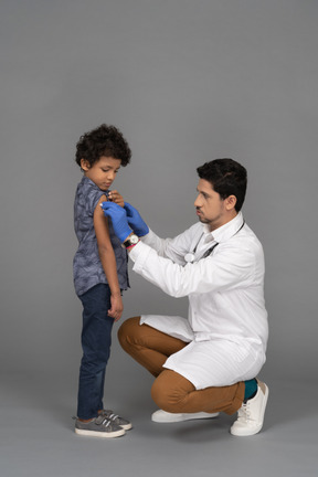 Médico e menino após vacinação