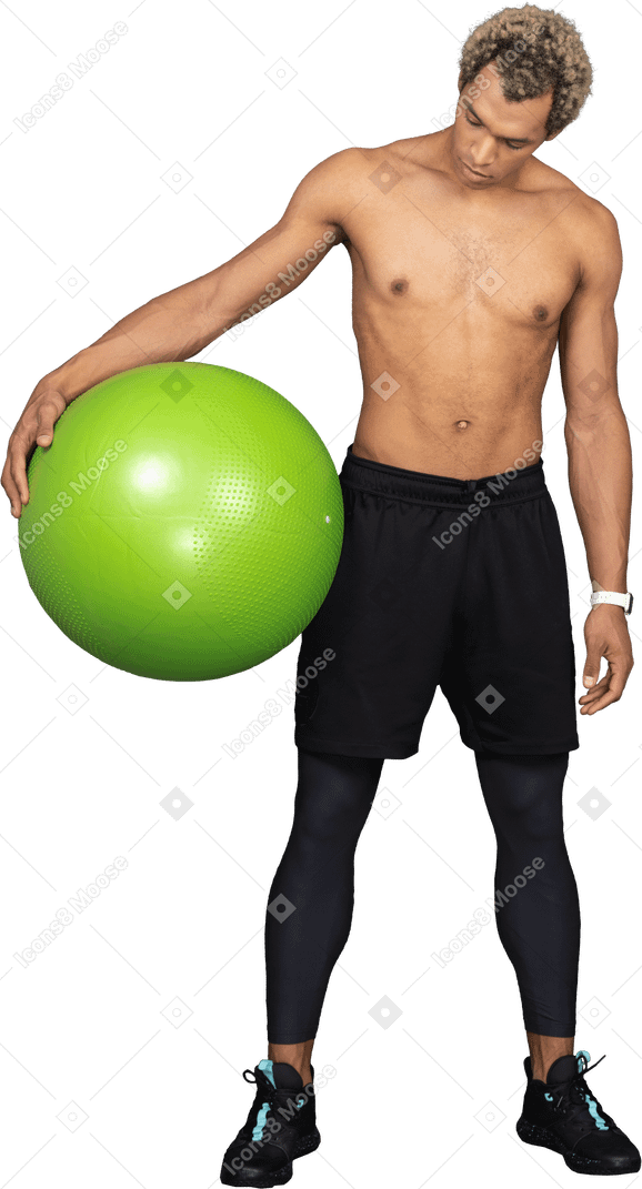 Vista frontal de un hombre afro sin camisa sosteniendo una gran pelota de gimnasia verde