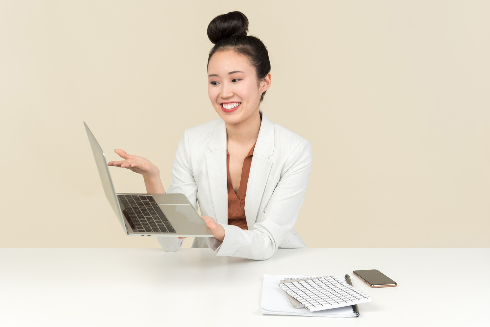 Young asian office woman sitting at the desk and pointing at laptop