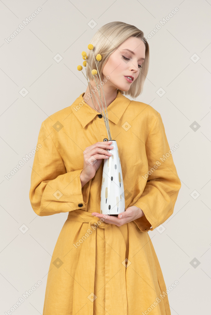 Dreamy young woman with eyes closed holding white vase