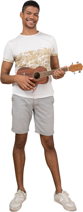 Vista frontale di un uomo che suona l'ukulele e sorride gioiosamente