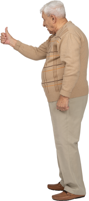 Vista laterale di un vecchio in abiti casual che mostra il pollice in su