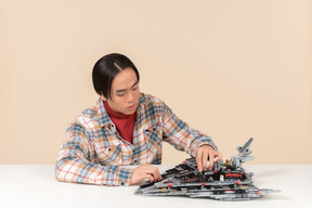 Un ragazzo asiatico geek in una camicia a scacchi