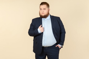 Young overweight man in suit touching jacket with a hand