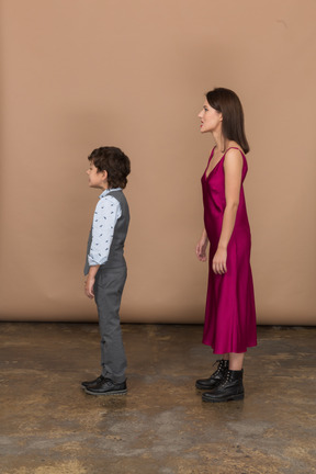 Boy and woman standing still in profile