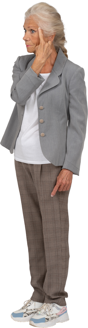 이마를 만지는 양복을 입은 노부인의 전면 모습
