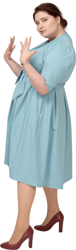 Vue latérale d'une femme en robe bleue faisant des gestes