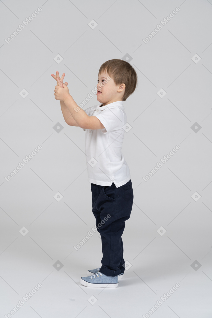 Vista lateral do menino levantando os braços