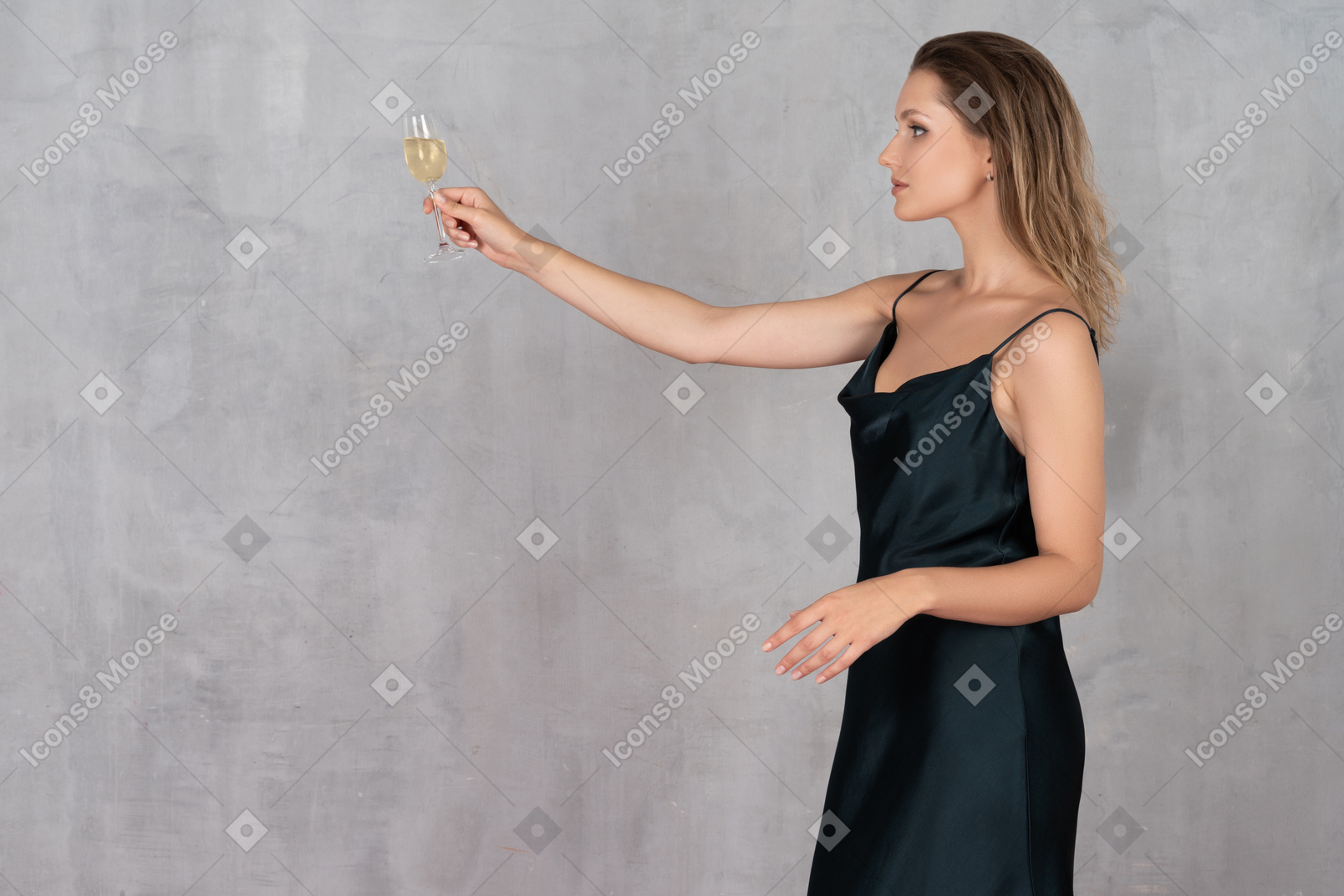 Side view of a young woman in night gown outstretching arm with a glass of champagne