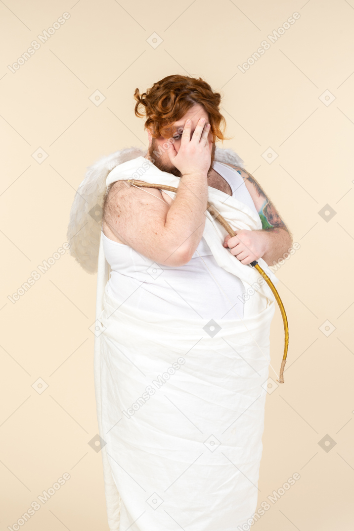 Big guy dressed as a cupid seems to be ashamed of something