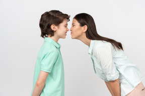 Heureuse mère et fils debout nez à nez