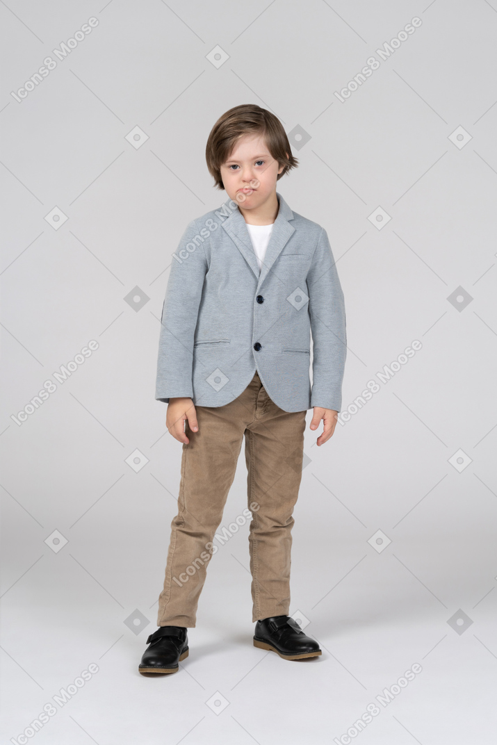 Front view of young boy in blue jacket and brown pants