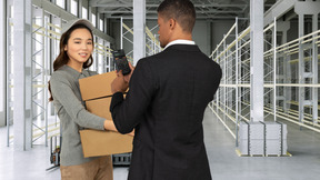 A deliverywoman bringing packages to a man in a warehouse