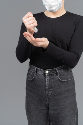 Person wearing mask sanitizing hands