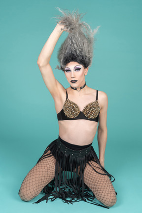 Drag queen standing on knees and taking off wig