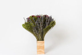 Violet flowers in wooden vase on white background