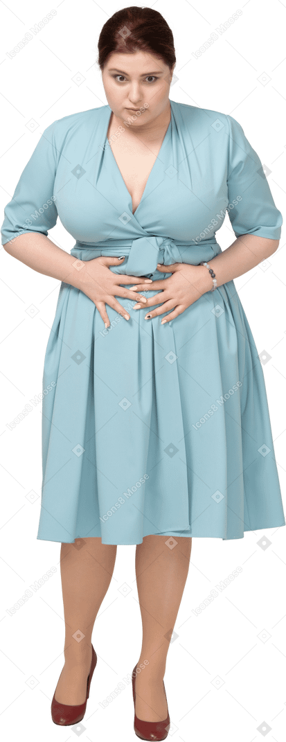 Front view of a woman in blue dress suffering from stomachache