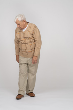 Vue de face d'un vieil homme en vêtements décontractés regardant vers le bas