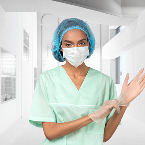 A woman wearing a surgical mask and gloves