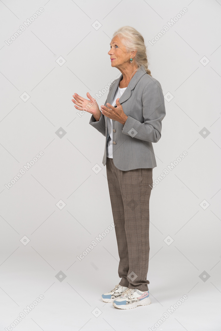 Side view of an old lady in grey jacket explaining something