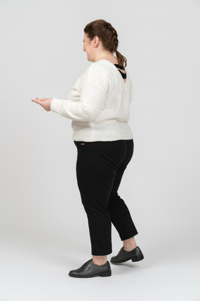 Plump woman in white sweater standing in profile