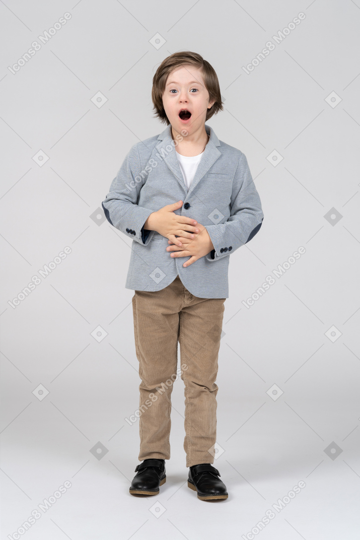 A boy with his mouth open and hands on his stomach