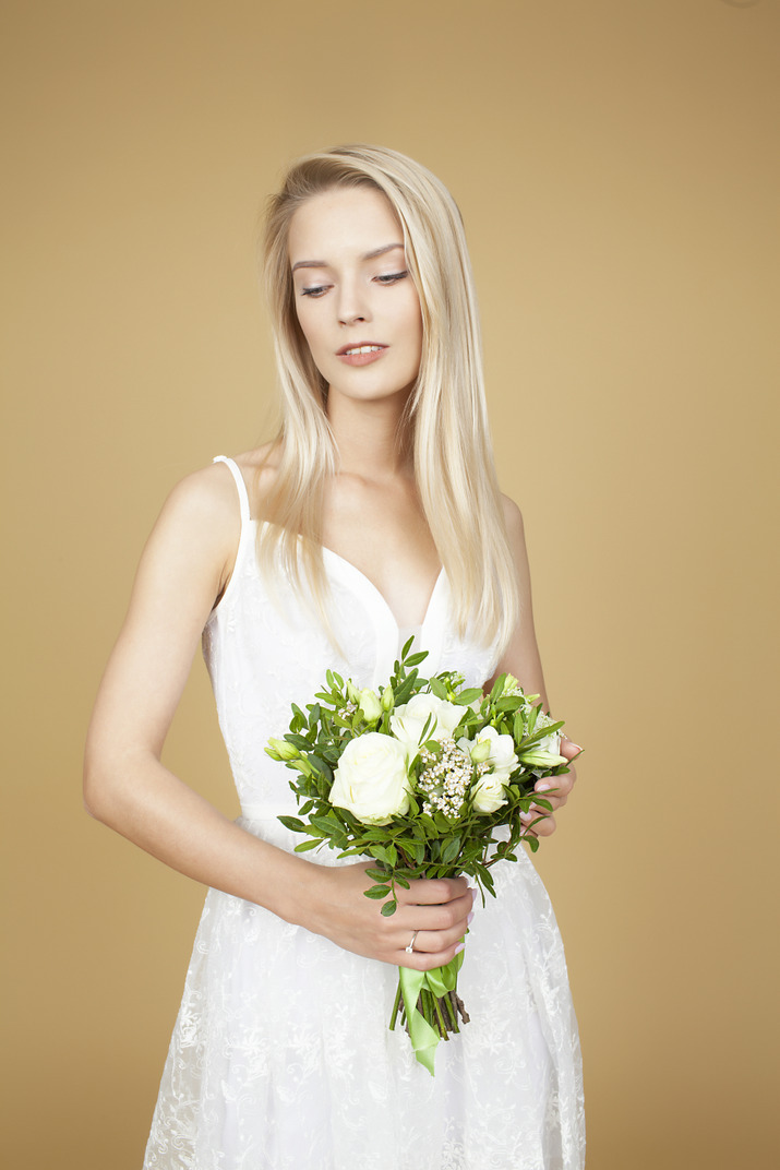 Beautiful bride holding a wedding bouquet of white flowers