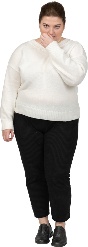 カメラ目線の白いセーターを着たプラスサイズの女性