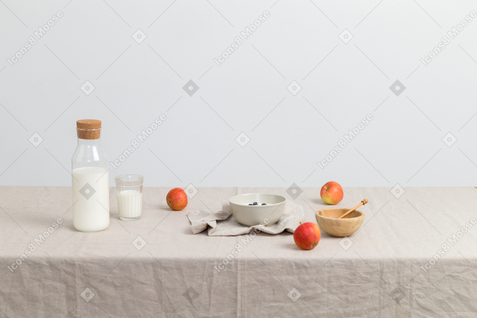Bottle of milk, glass og milk, red apples and bowls