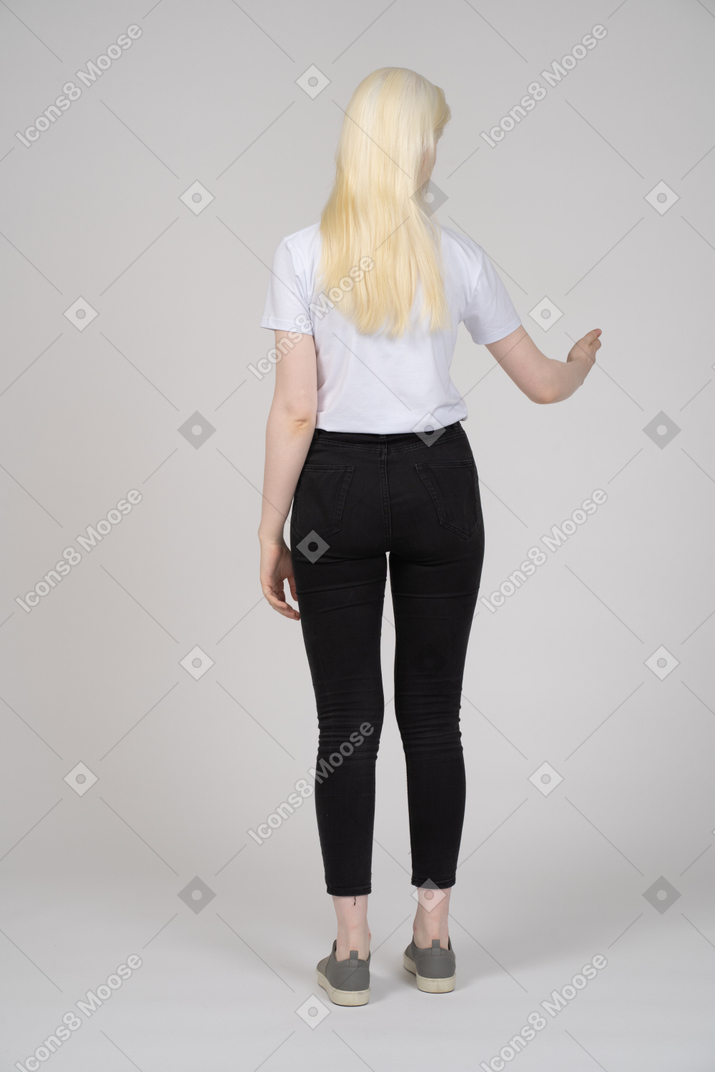 一名年轻女子站立并伸出手臂的后视图