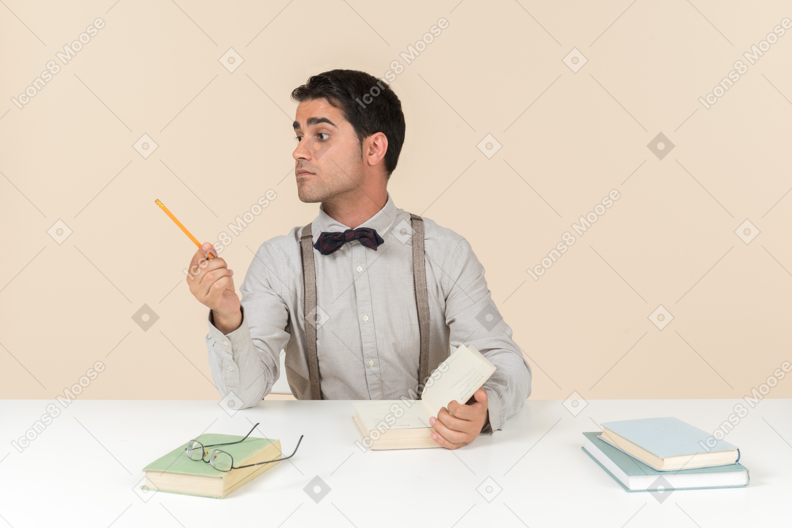 Erwachsener student, der am tisch sitzt und beiseite mit einem stift zeigt