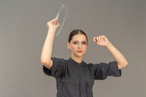 Front view of a young woman in a jumpsuit holding glass plate