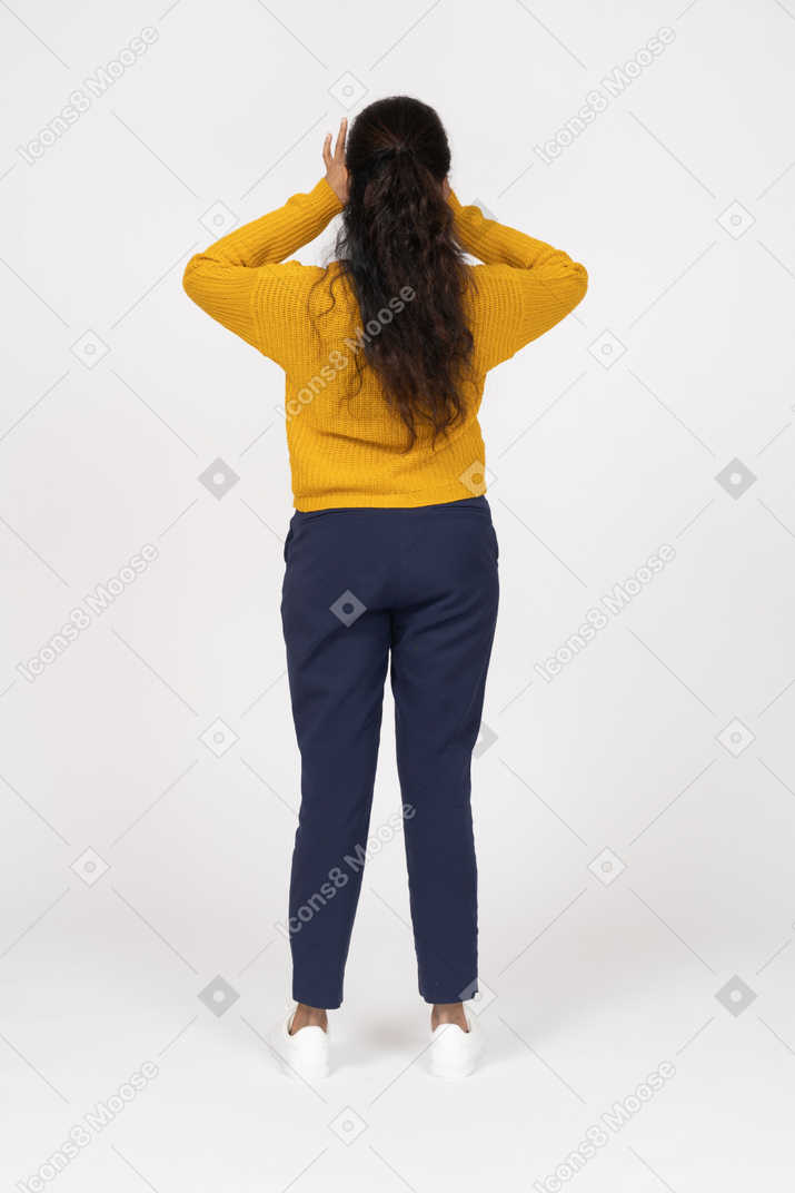 Rear view of a girl in casual clothes looking through fingers