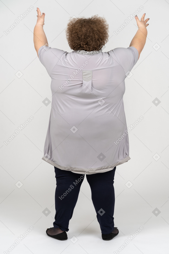 上げられた手を持つ女性の背面図