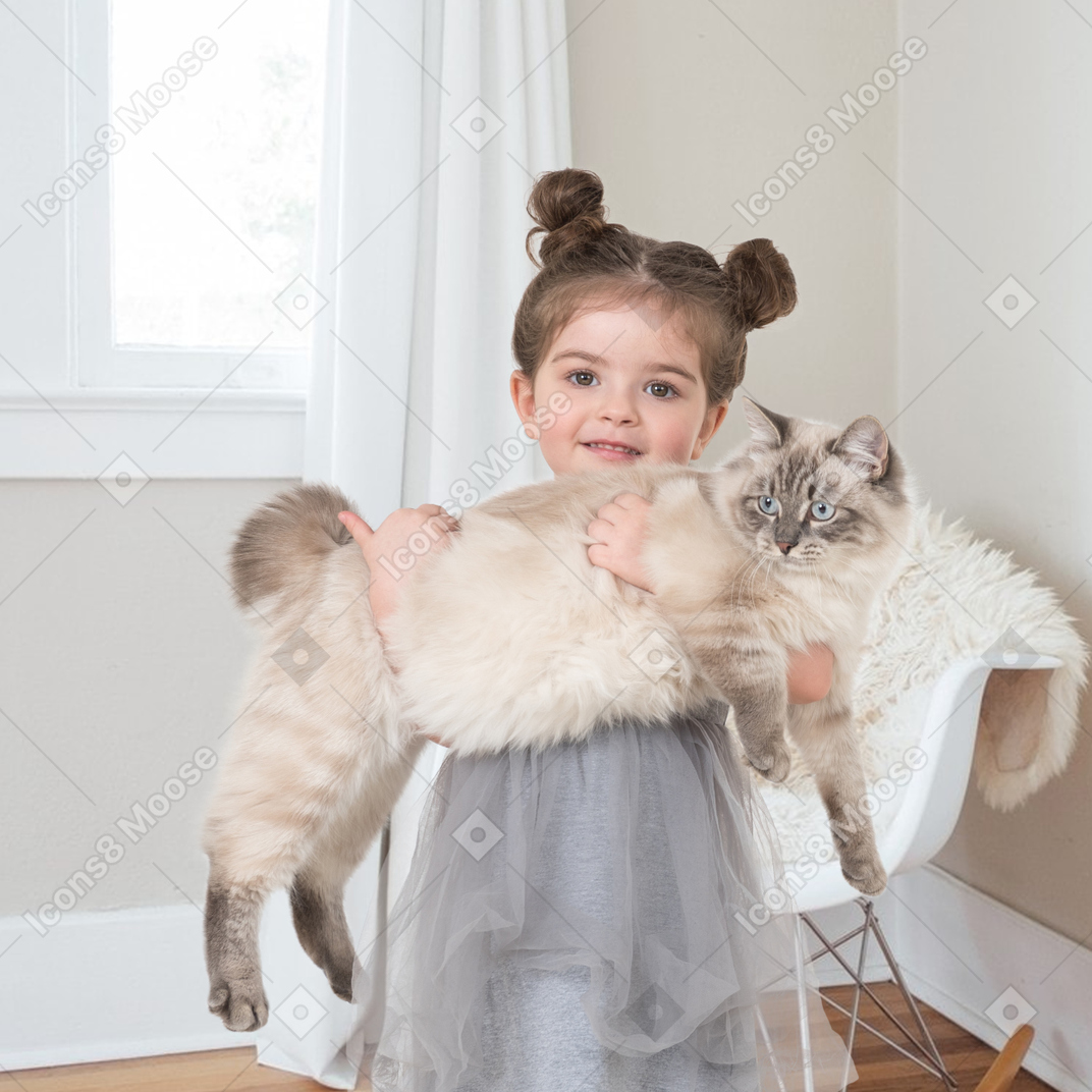 A little girl holding a cat in her arms