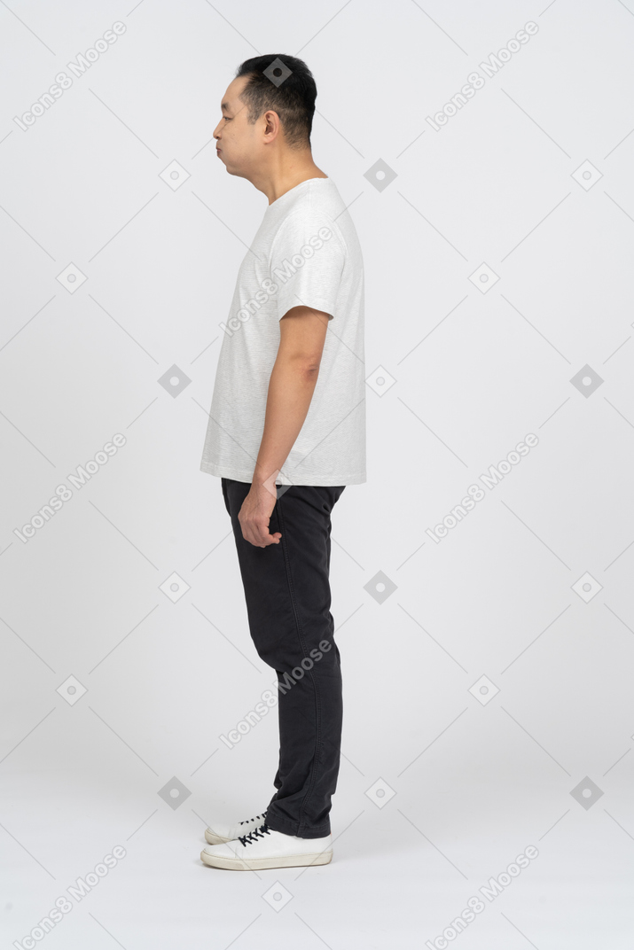 Side view of a man in casual clothes making funny face