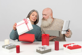 Elegant elderly couple unpacking christmas gifts